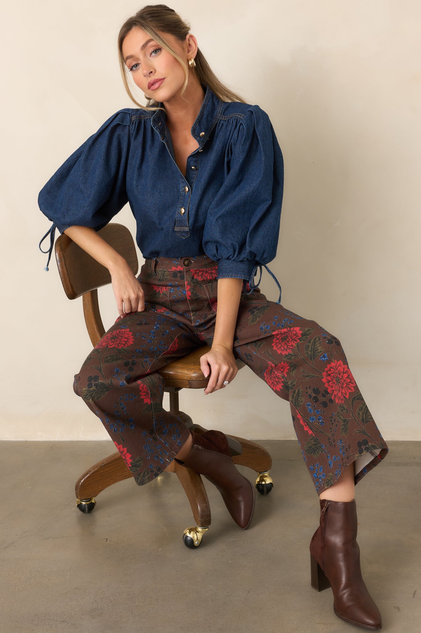 Button-front denim top with gathered shoulders, oversized three-quarter sleeves, tied cuffs, and a flattering high-low hem.