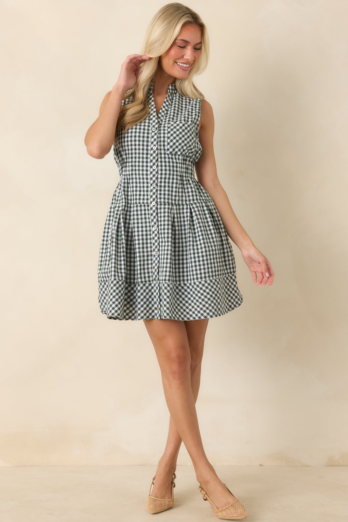 Button-front gingham dress featuring a tailored collar, lined construction, elastic waistband, and comfortable everyday silhouette.