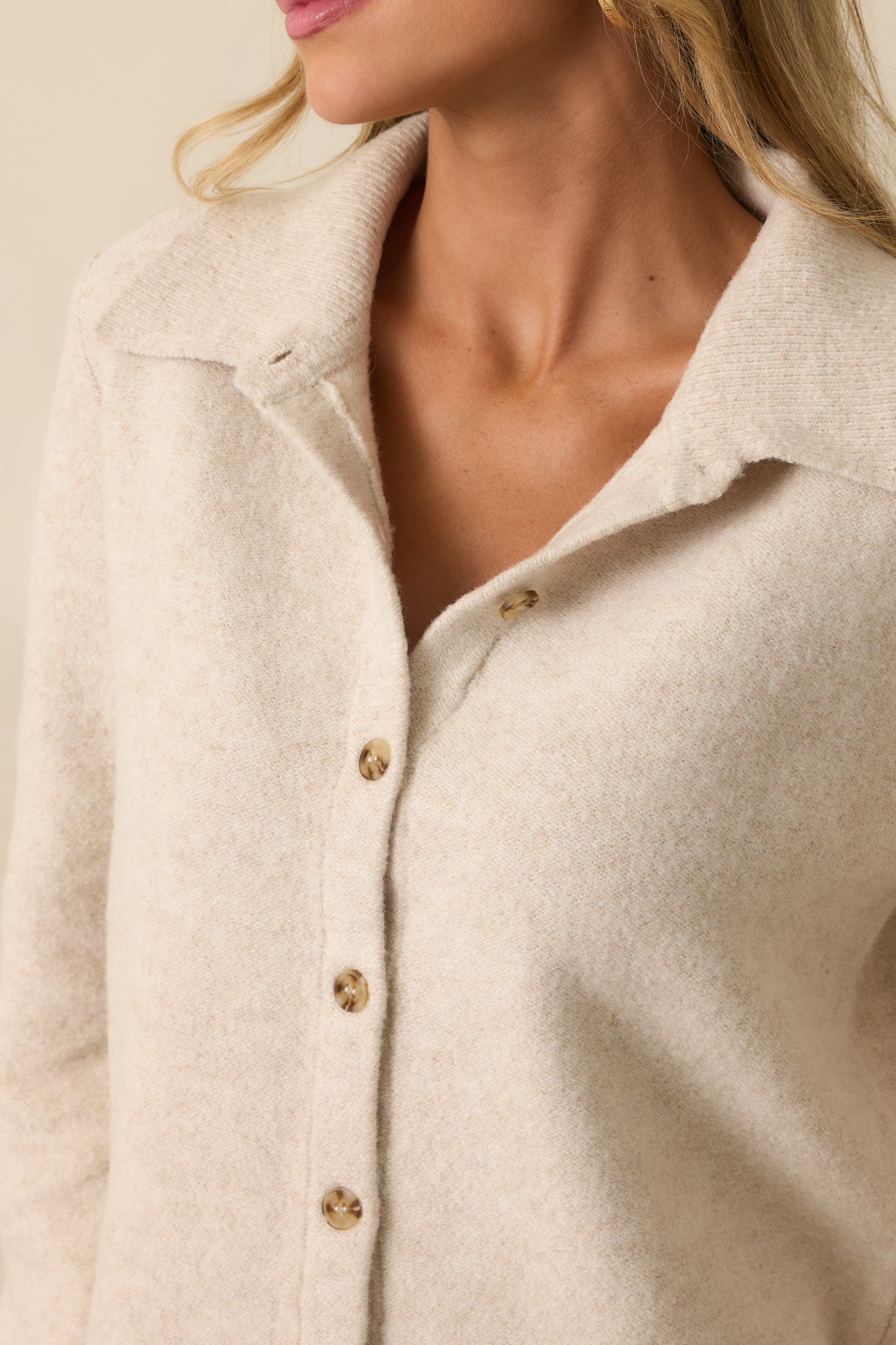 Functional button front closure on the ivory knit cardigan with collared neckline