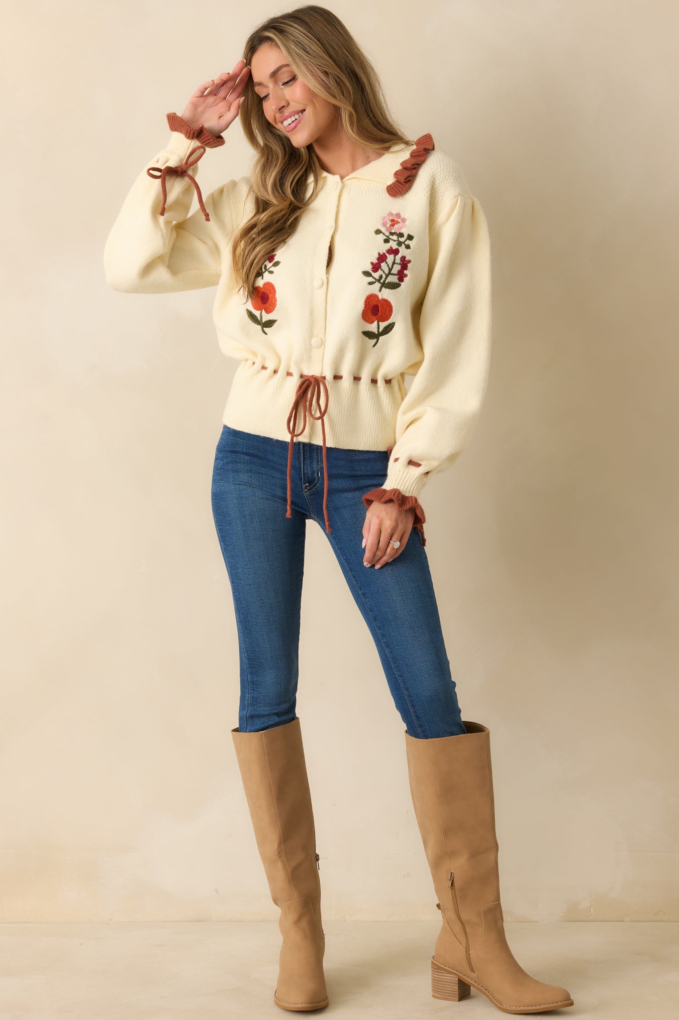 Button-up ivory cardigan featuring puffed sleeves, rust accents, and embroidered floral details on the front.