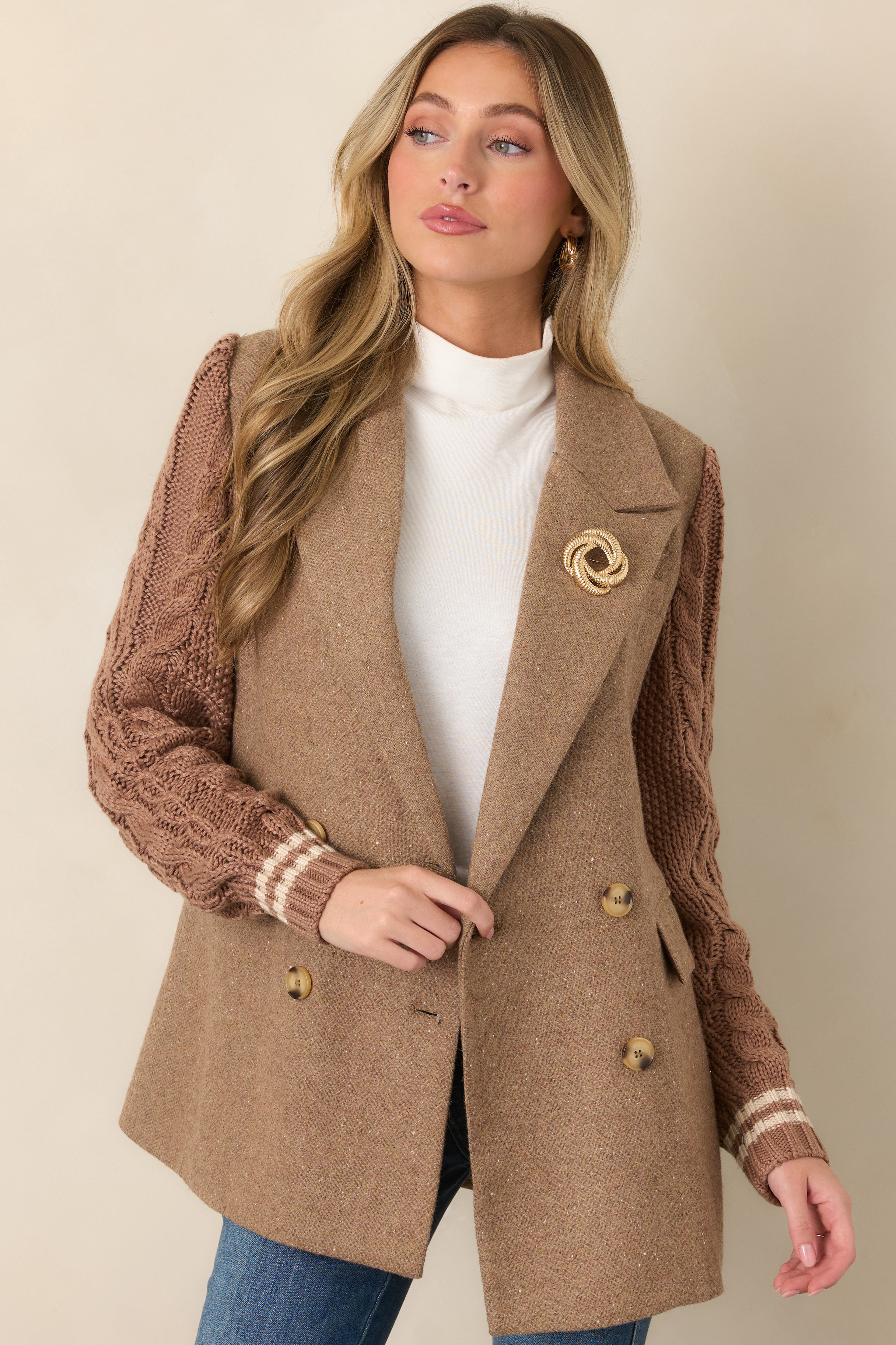 Close view of the camel blazer’s notched lapels, double-breasted button closure, and structured wool-blend fabrication.