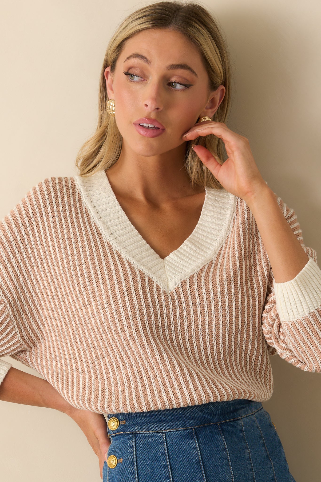 Close view of striped sweater fabric in camel brown and ivory with wide ribbed neckline.