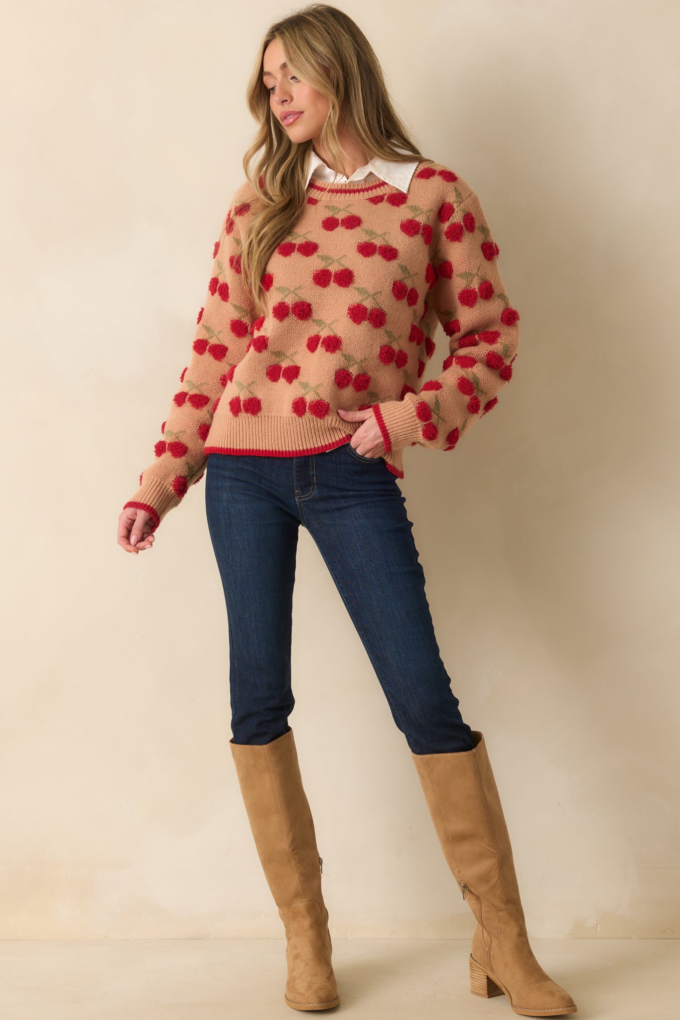Camel brown knit sweater with red chenille cherry motifs, crew neckline, and long sleeves.