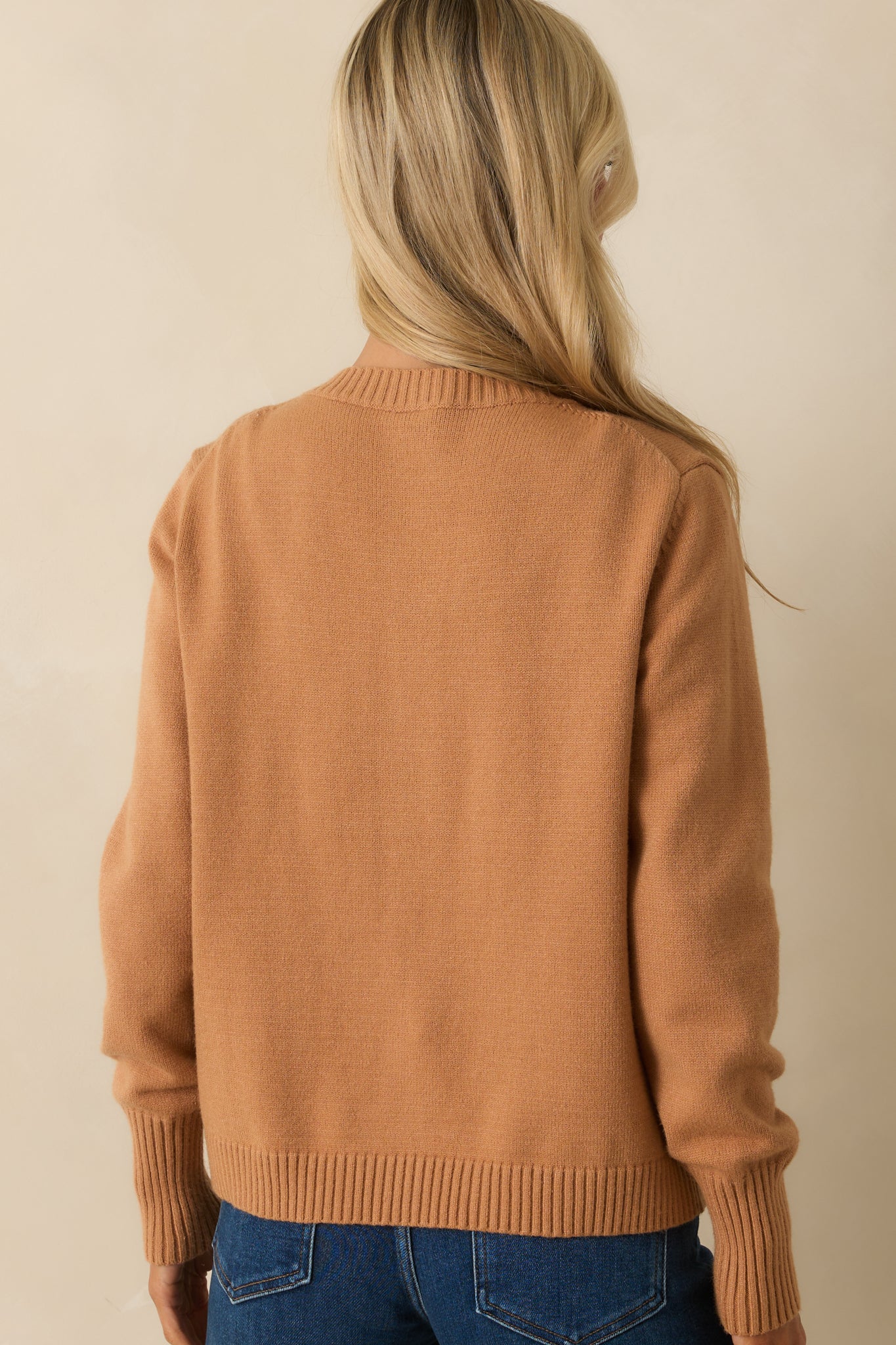 A back view of the camel brown cardigan showing the relaxed fit and long sleeves.