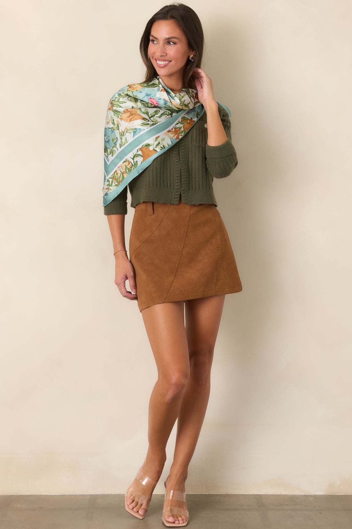 Warm camel faux suede mini skirt with curved panel seams, whipstitch detailing, and a gently flared silhouette.
