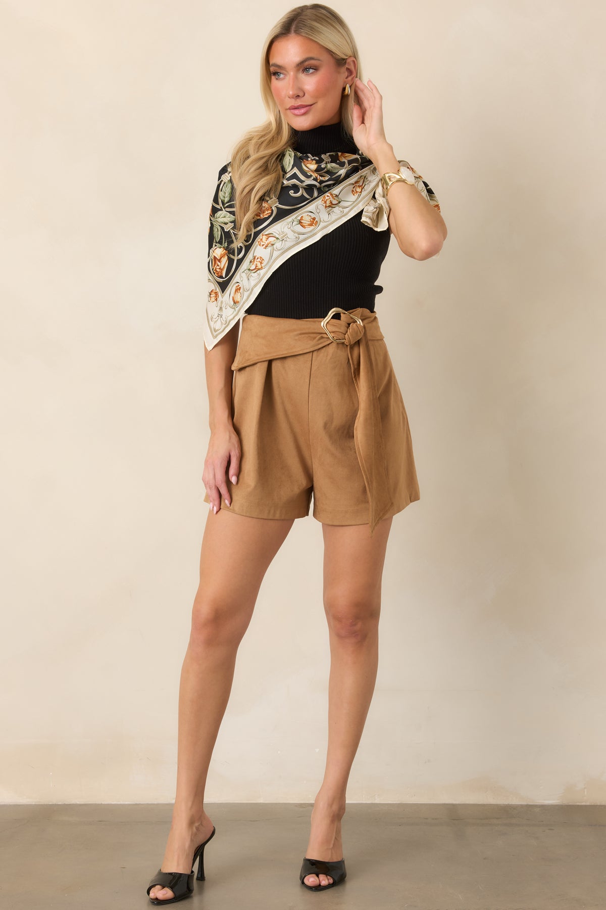 Camel faux suede pants with a defined waist, draped sash belt, gold-tone buckle, and tailored pleated legs.