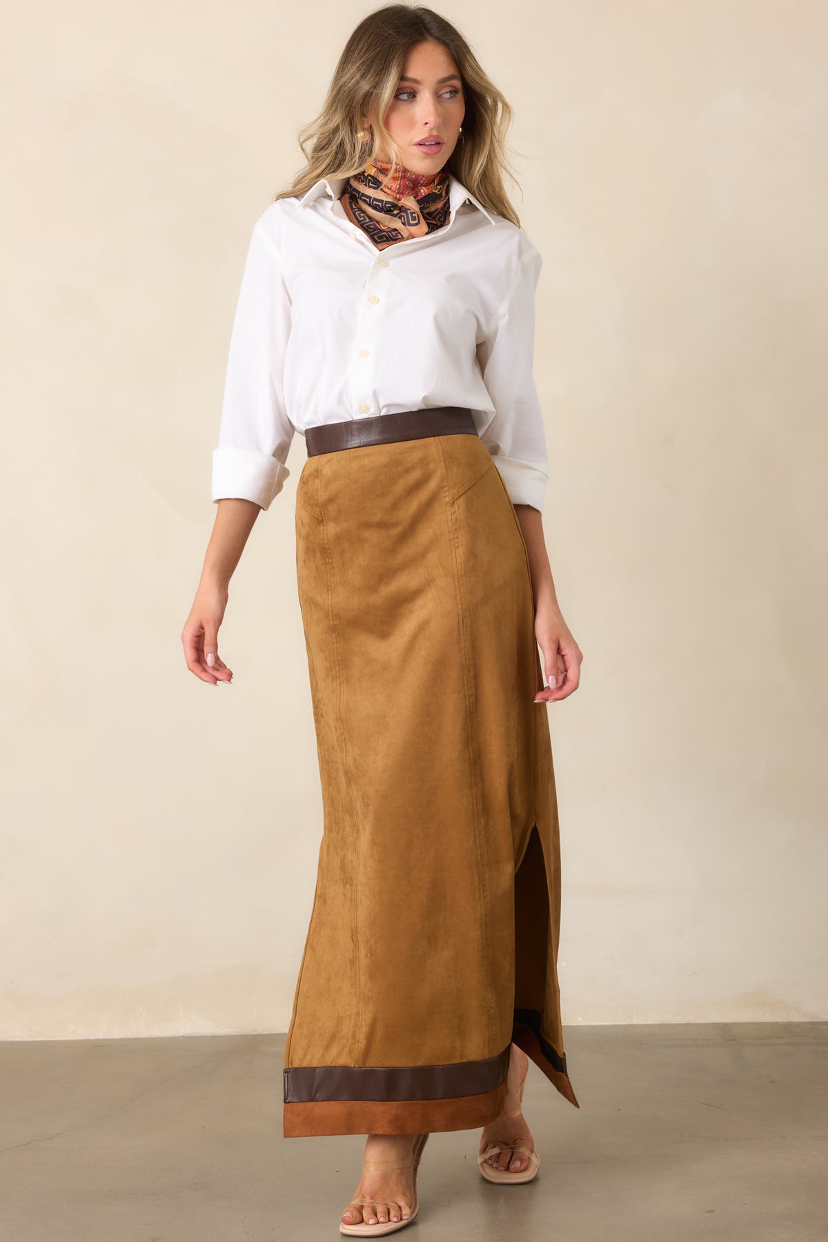 Camel faux suede maxi skirt with vertical seams and contrast trim framing the lower hem.
