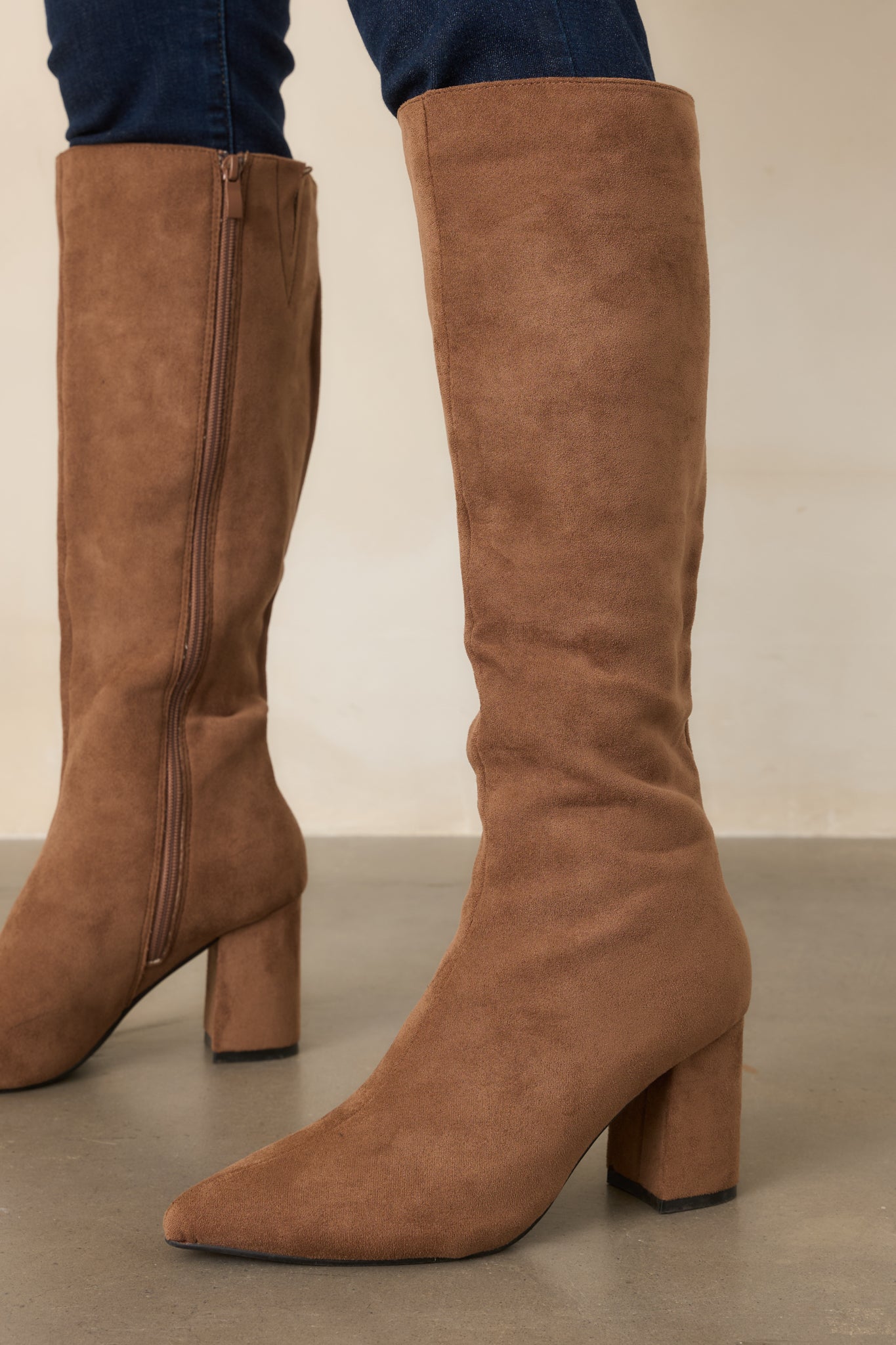 Refined camel boots showcasing their streamlined silhouette, tall fitted shafts, and elegant pointed fronts.