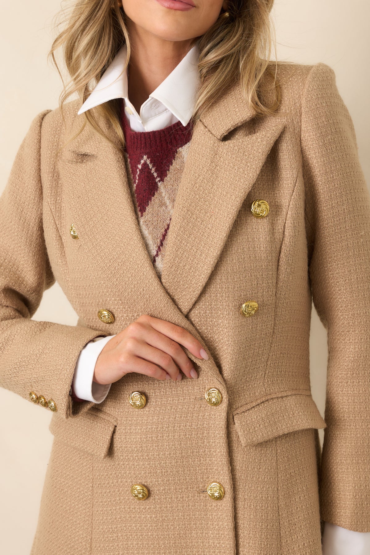 Gold-tone button closures and textured woven fabric add refined detail to the camel topcoat.