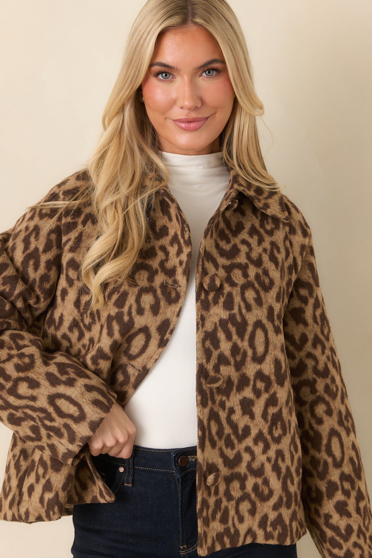 Side pockets sit along the front of the camel leopard jacket beneath its oversized button closure.