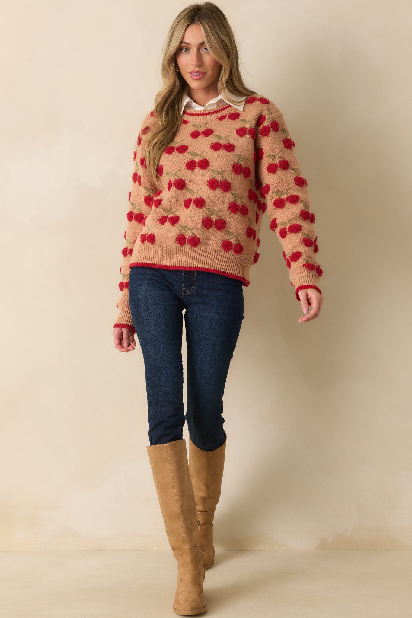 Long-sleeve camel sweater highlighted by a cozy knit texture and playful red cherry embroidery.