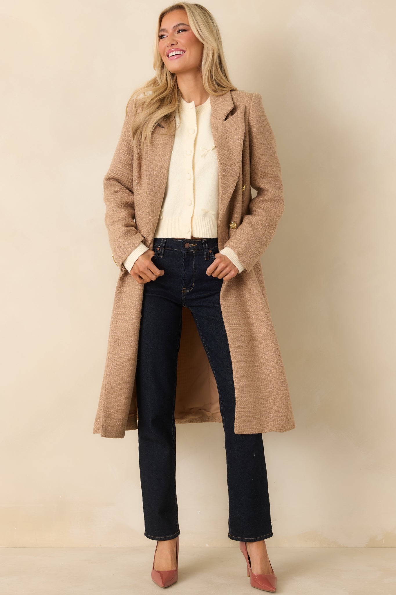 Full view of the camel topcoat showing long sleeves with buttoned cuffs and functional front flap pockets.