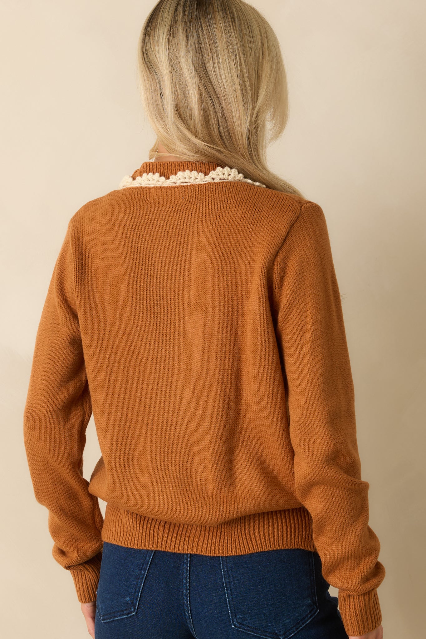 A back view of the caramel brown cardigan featuring a plain knit design with ribbed hem and long sleeves.
