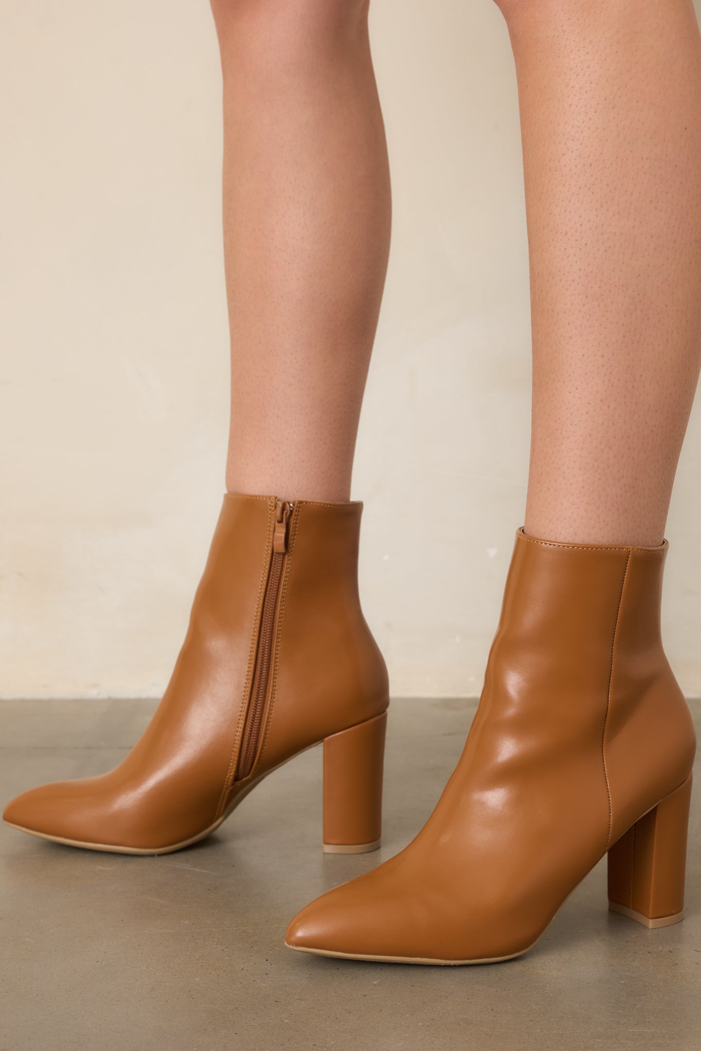Caramel faux leather ankle boot showcasing the outer seam detailing and structured ankle shaft.