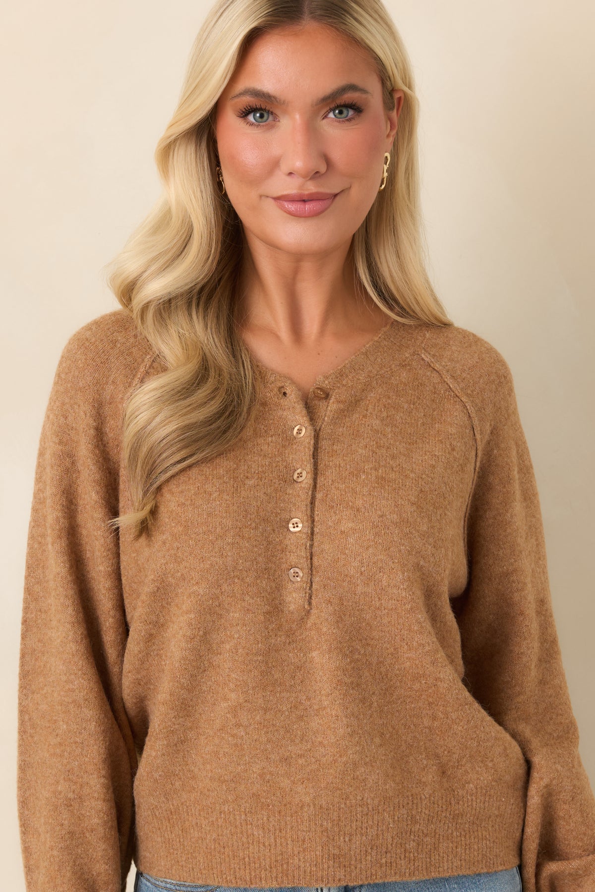 Caramel brown knit top highlighting the Henley neckline and tonal buttons along the partial front placket.