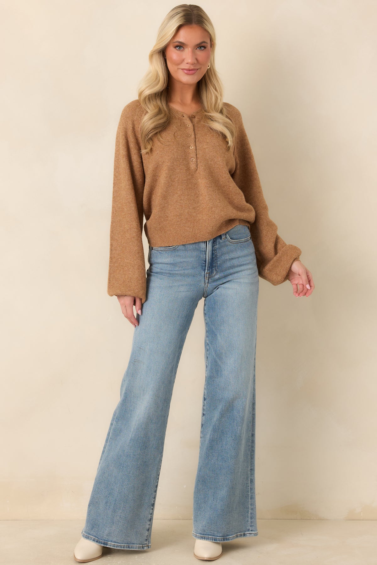 Caramel knit pullover showcasing tonal buttons, softly textured fabric, and a relaxed shape with a cropped ribbed hem.