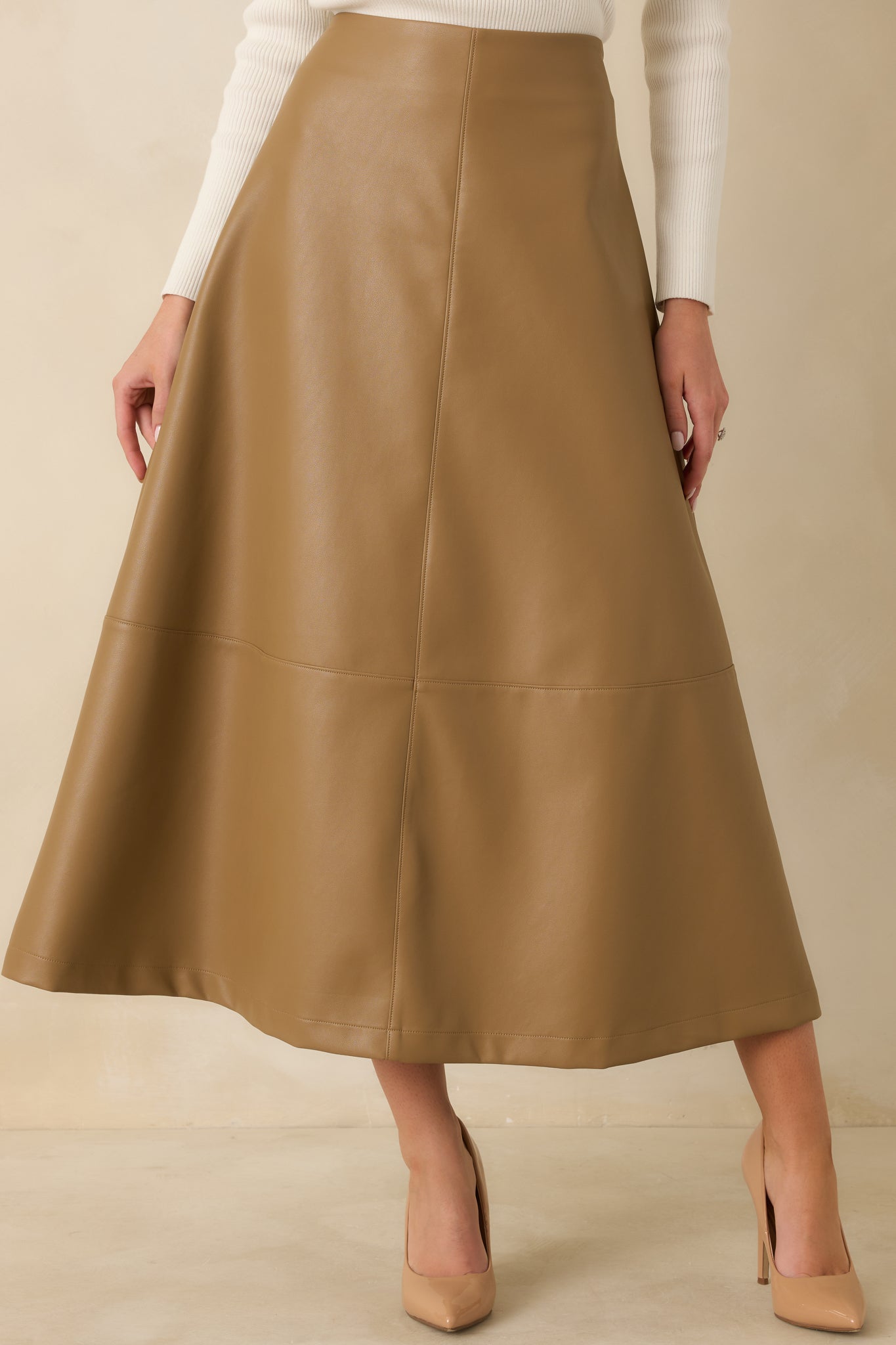 Warm caramel skirt showcasing vertical and horizontal panel seams that add subtle structure and dimension.