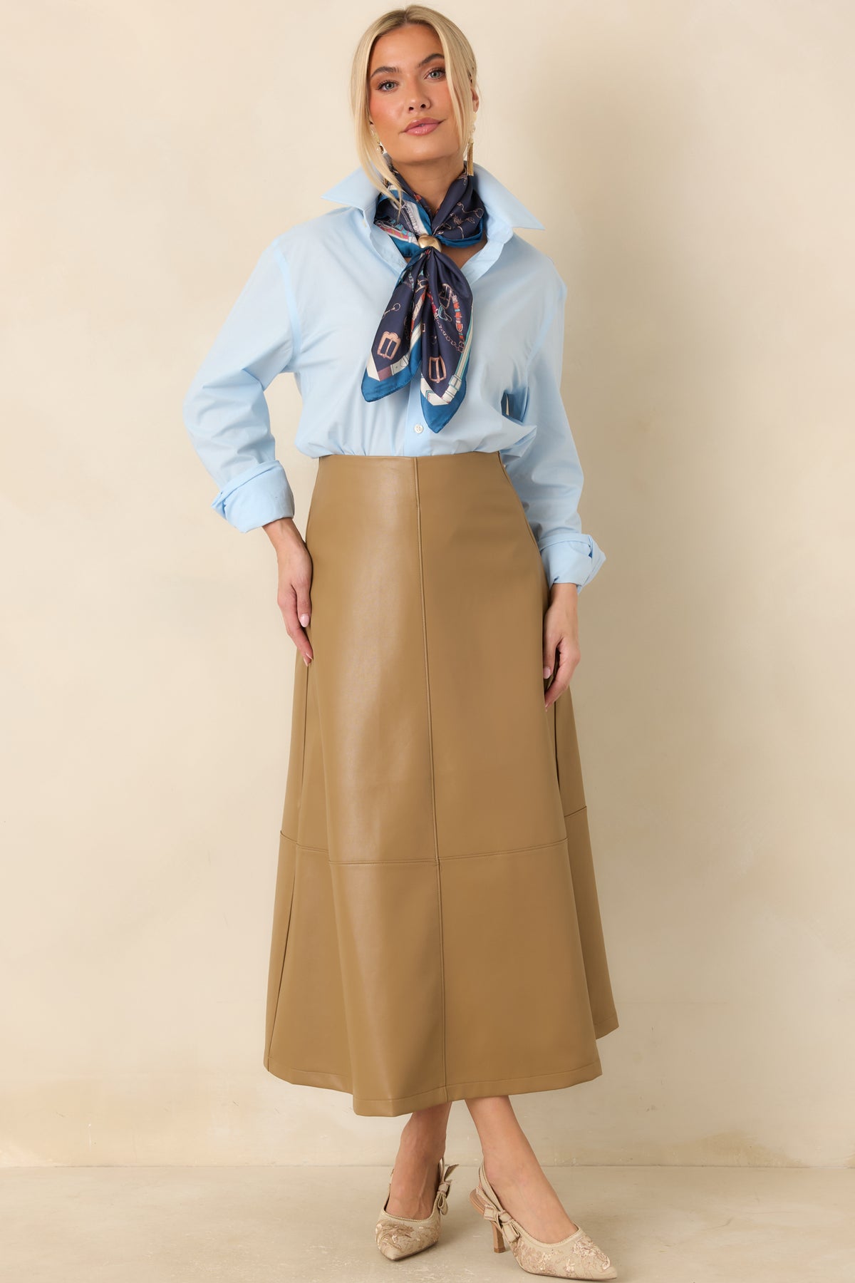 Caramel vegan leather midi skirt with a high-rise waist, fitted silhouette, and flared hem.