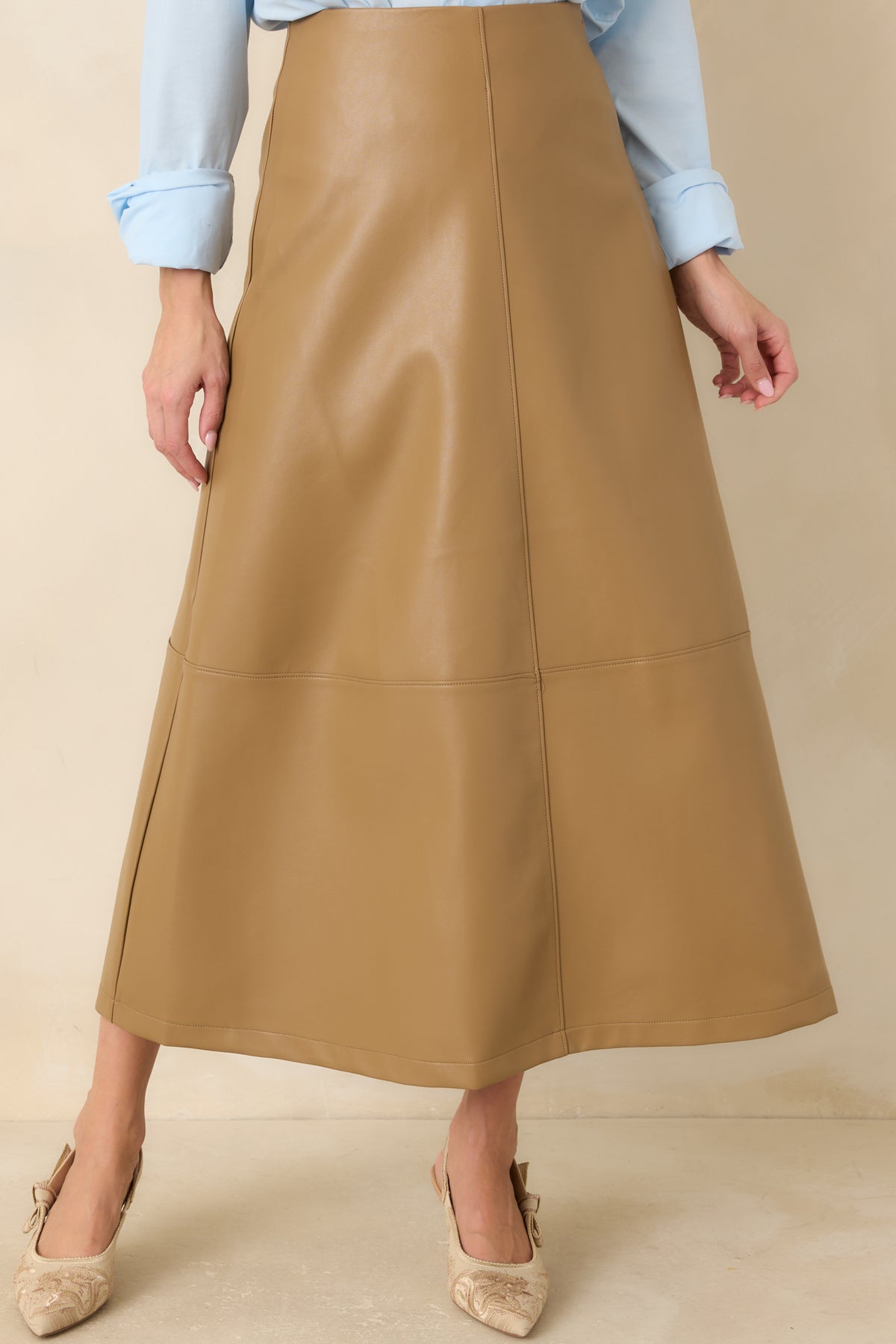 Caramel vegan leather skirt highlighting the high-rise waistband and smooth fitted upper section.