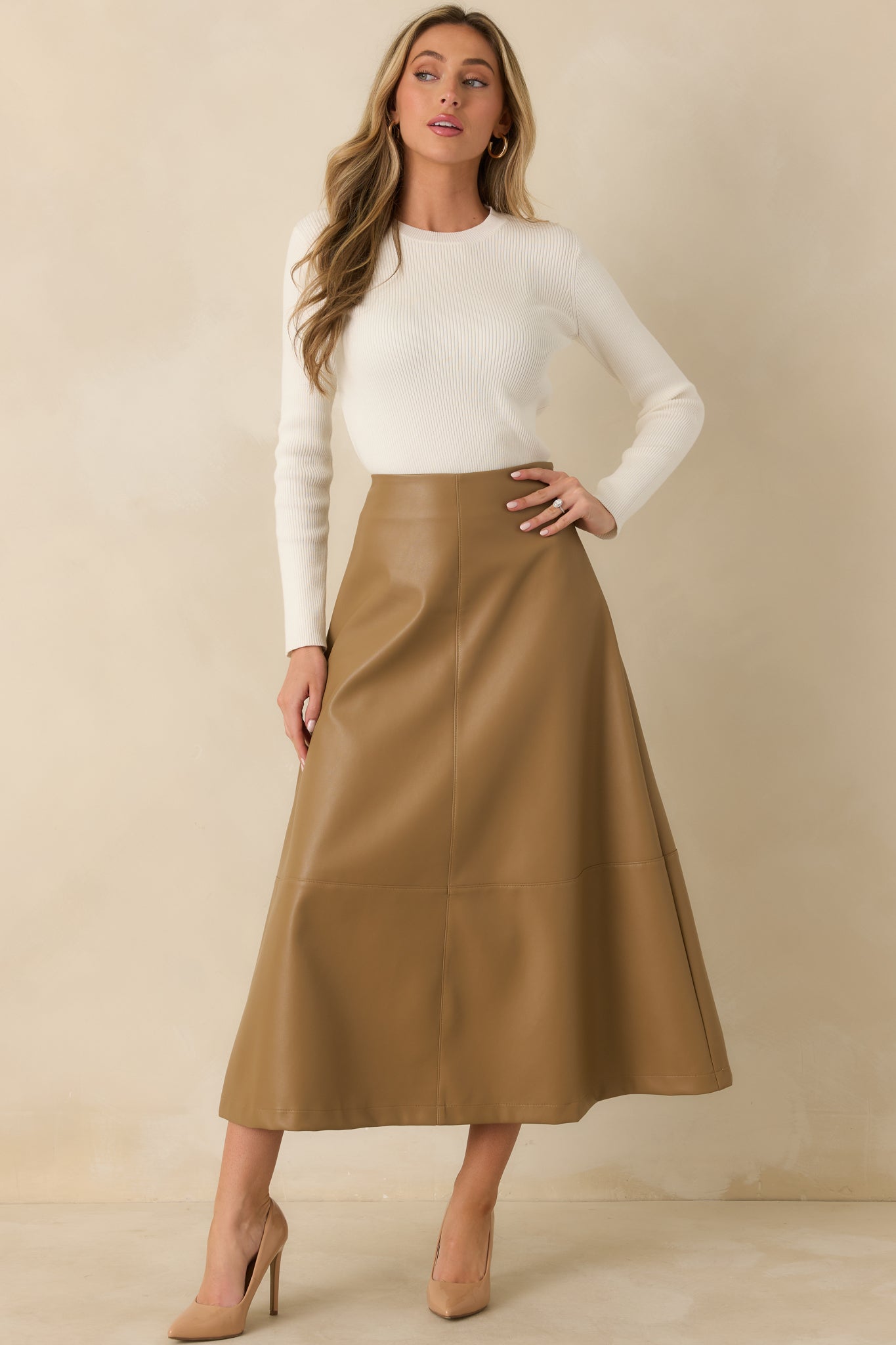 Caramel vegan leather midi skirt featuring a fitted high-rise waist and beautifully flared silhouette.