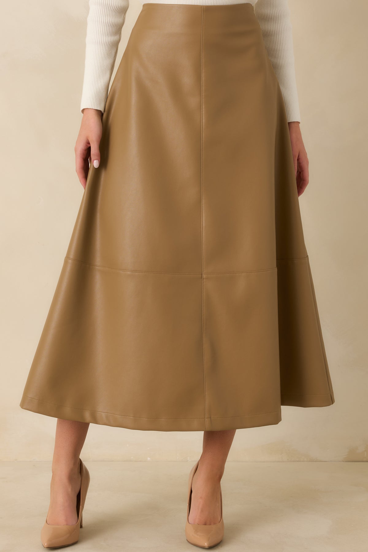 Caramel vegan leather skirt highlighting the fitted high-rise waist and sleek, smooth finish.