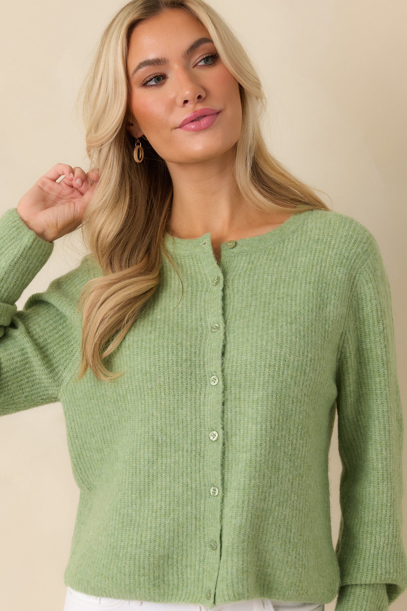 Front detail of cardigan highlighting relaxed fit and ribbed knit fabric.