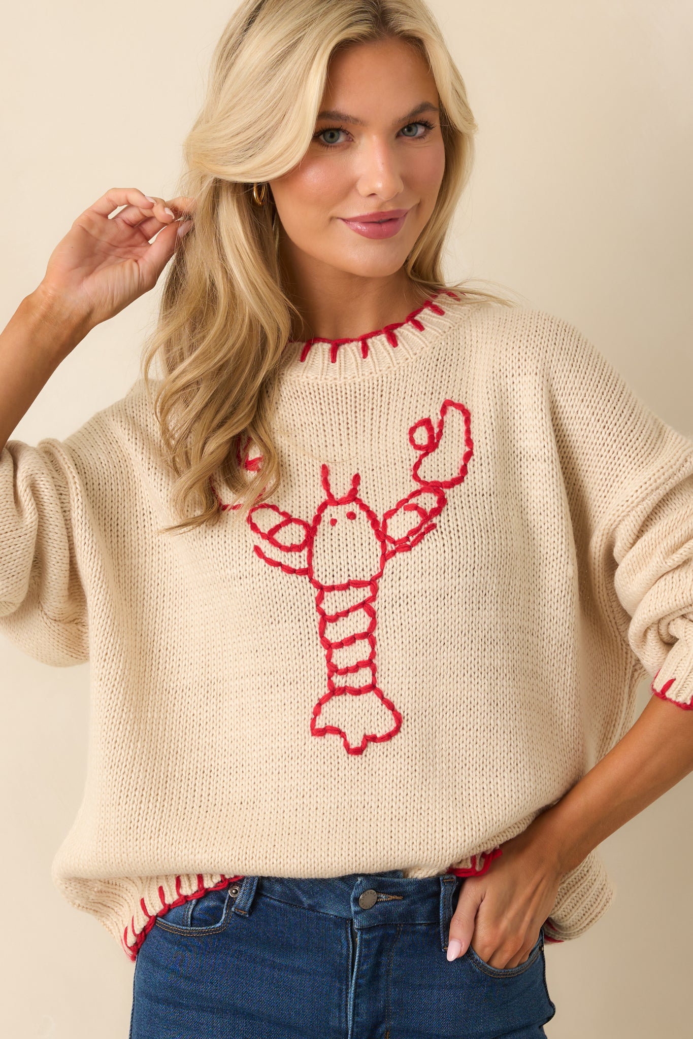 Casual pullover with contrast whipstitch details and a statement red lobster motif.