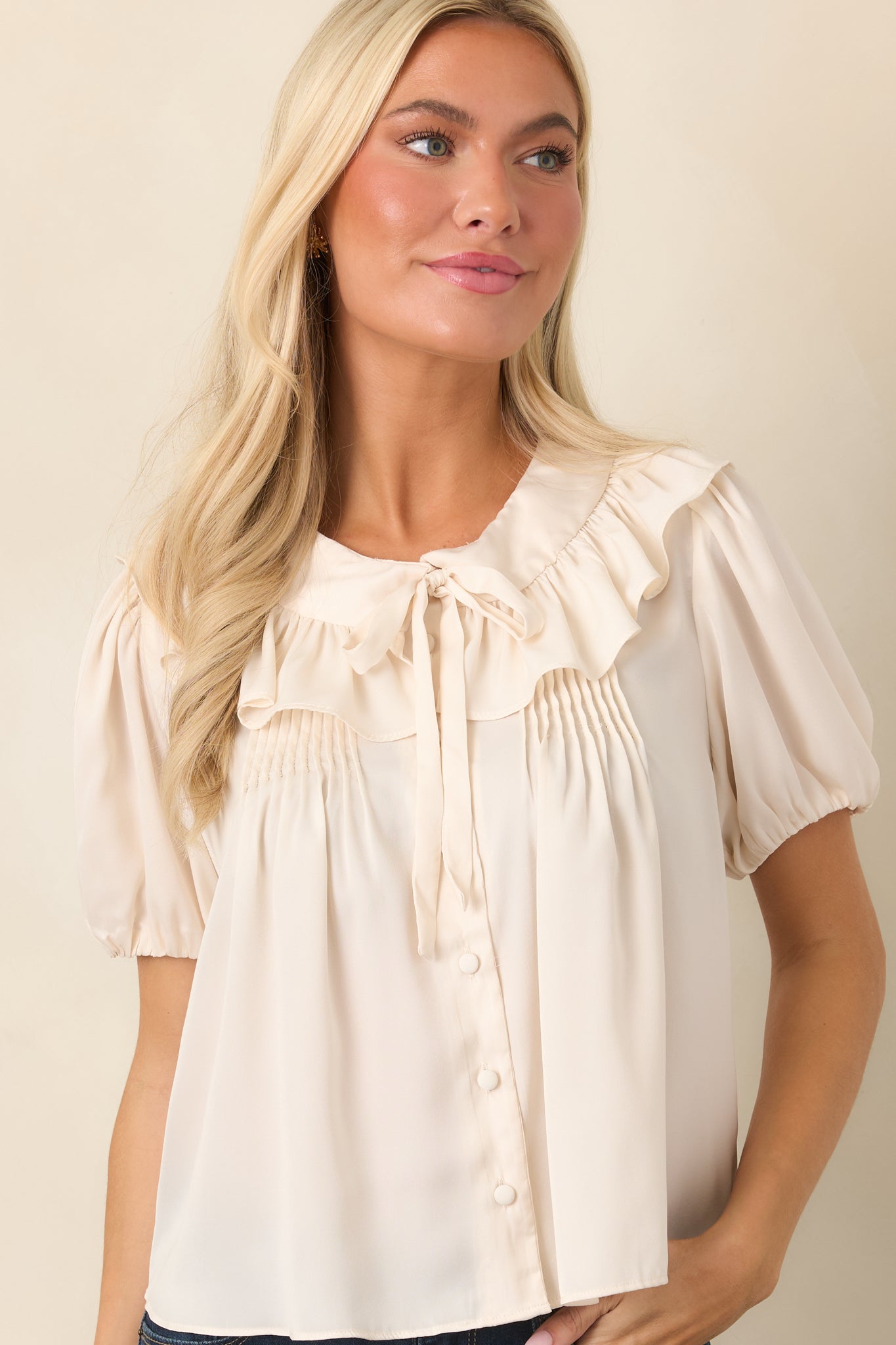 Champagne blouse detail featuring a short puff sleeve finished with an elasticized cuff for softly gathered volume.