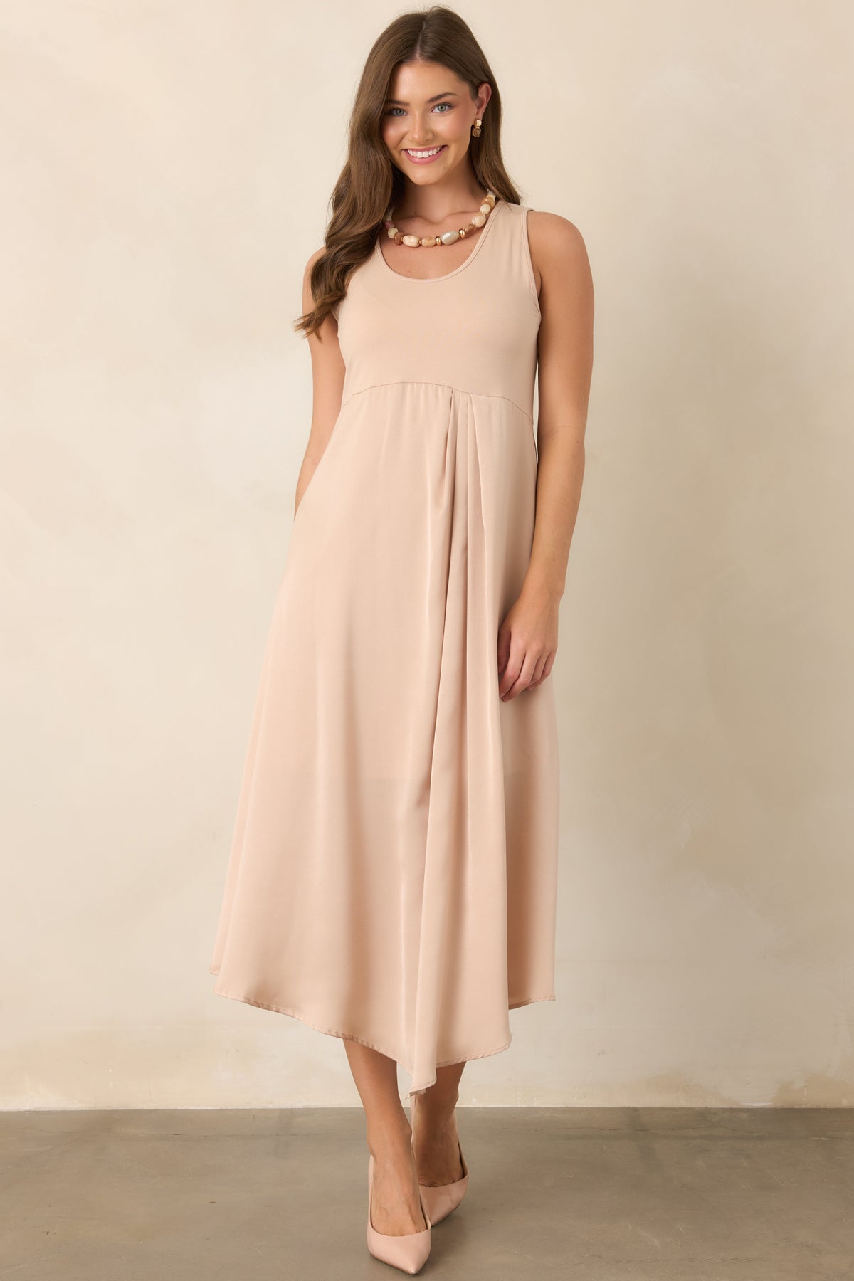 Elegant champagne midi dress featuring a smooth scoop-neck knit top and flowing satin skirt with a softly polished finish.