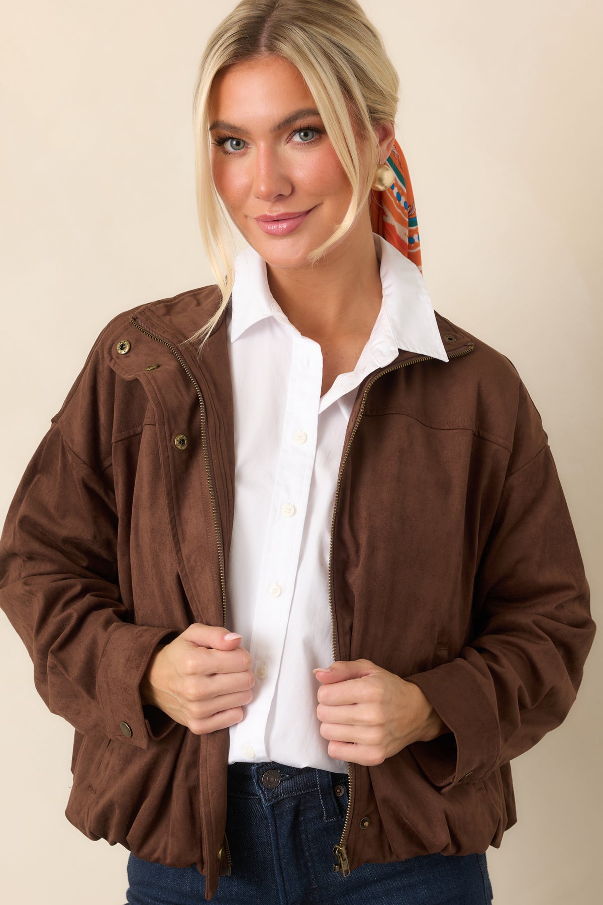 Elasticized hem gathers the chocolate bomber into a softly rounded silhouette.