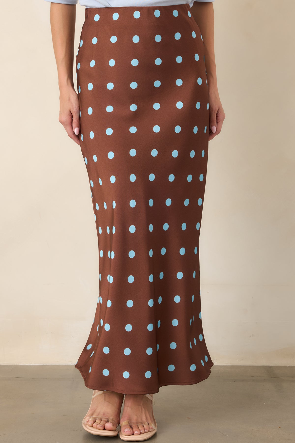 Chocolate brown polka dot skirt emphasizing the graceful drape and softly angled lines created by its bias-cut silhouette.