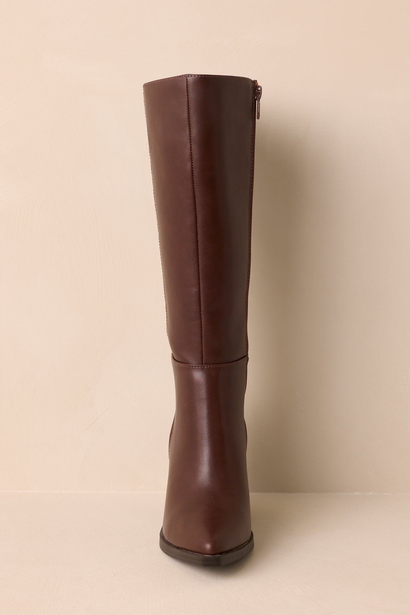 Front view of chocolate brown boot displaying pointed toe and sleek silhouette.