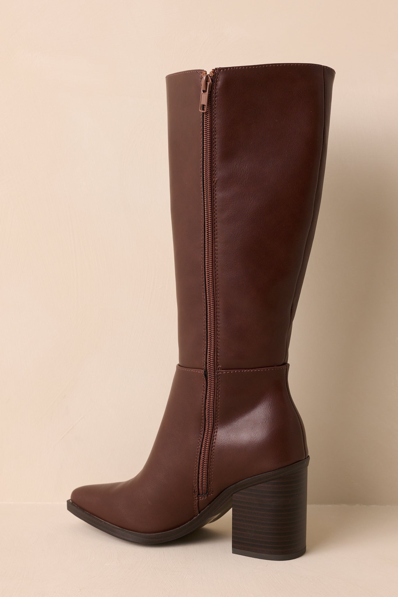 Rear view of chocolate brown boot displaying smooth faux leather back, structured shaft, and block heel.