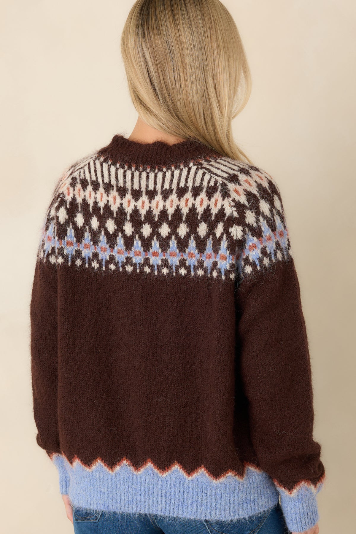 Rear of the chocolate brown Fair Isle sweater showing the patterned yoke and periwinkle ribbed hem.