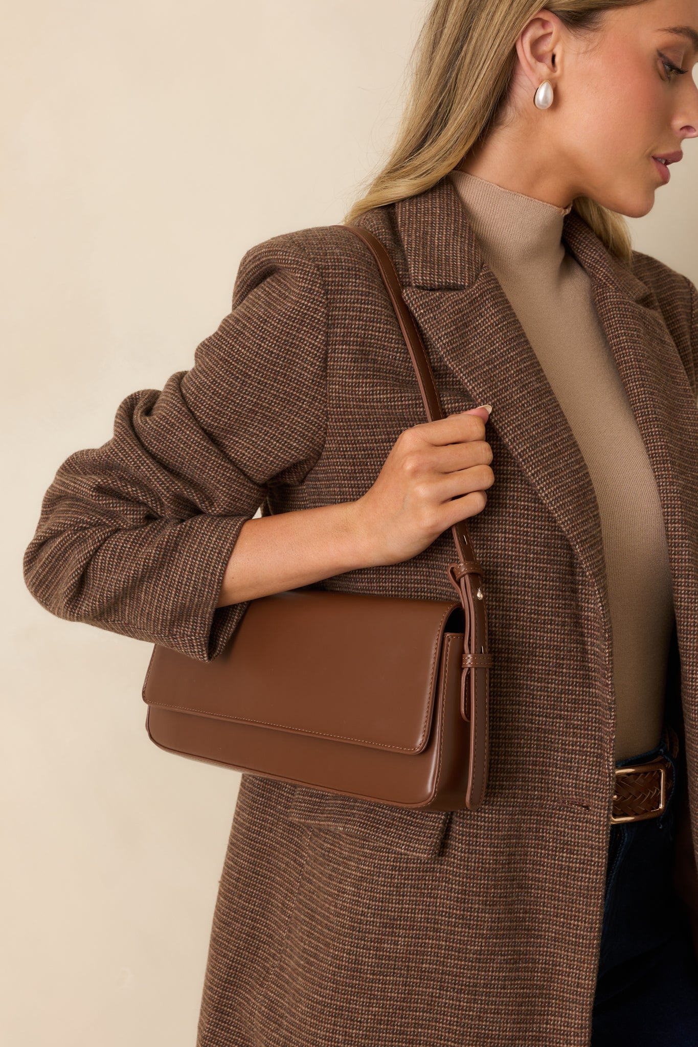 Chocolate brown faux leather handbag with rectangular baguette shape, fold-over flap, and adjustable shoulder strap.