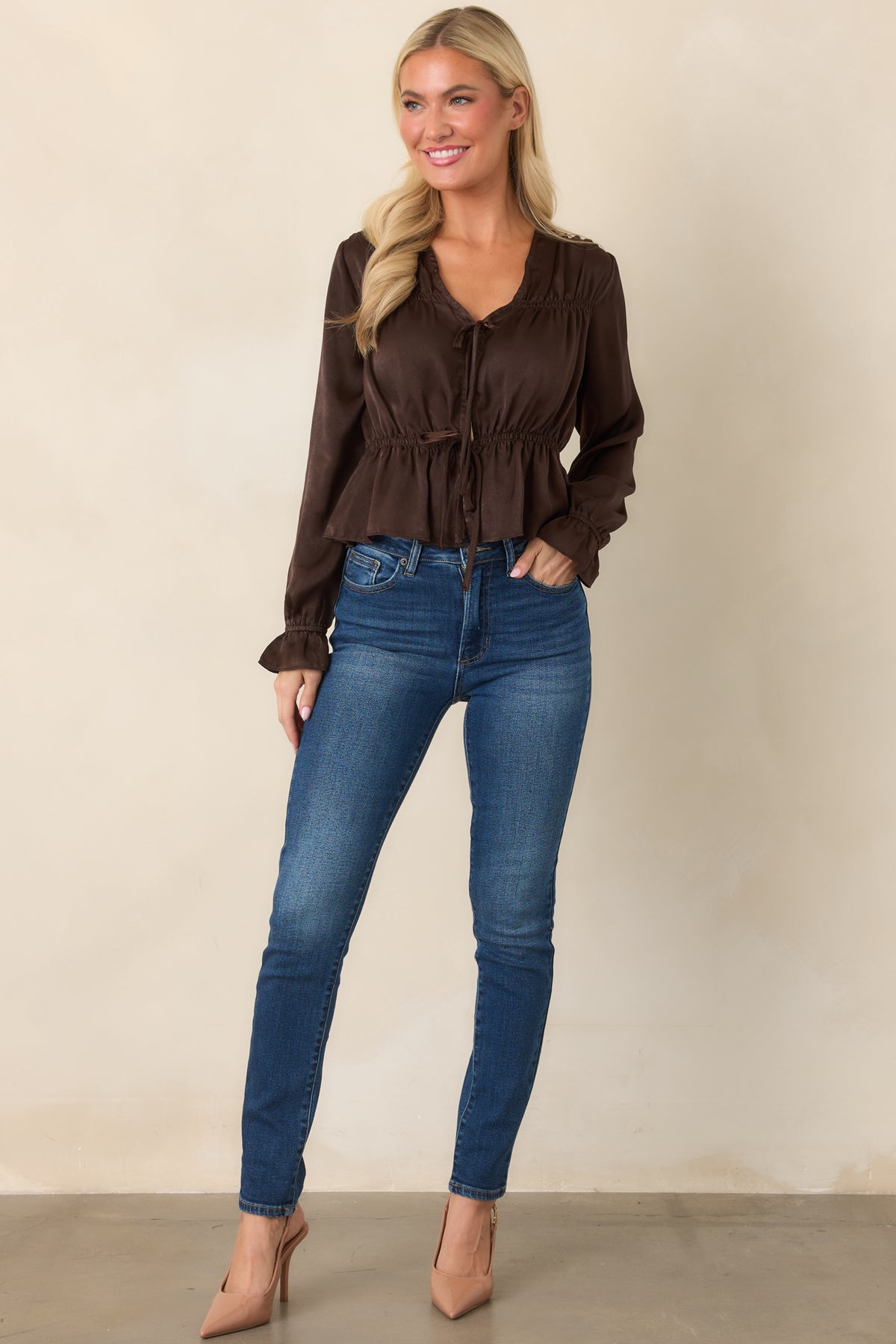 Chocolate brown blouse featuring a feminine V-neckline, gathered shoulders, billowy poet sleeves, an adjustable drawstring waist, and a flared peplum silhouette.