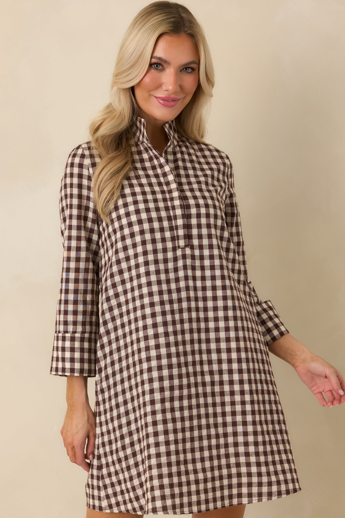 Chocolate brown and ivory gingham dress featuring three-quarter sleeves and a softly structured cotton-blend construction.
