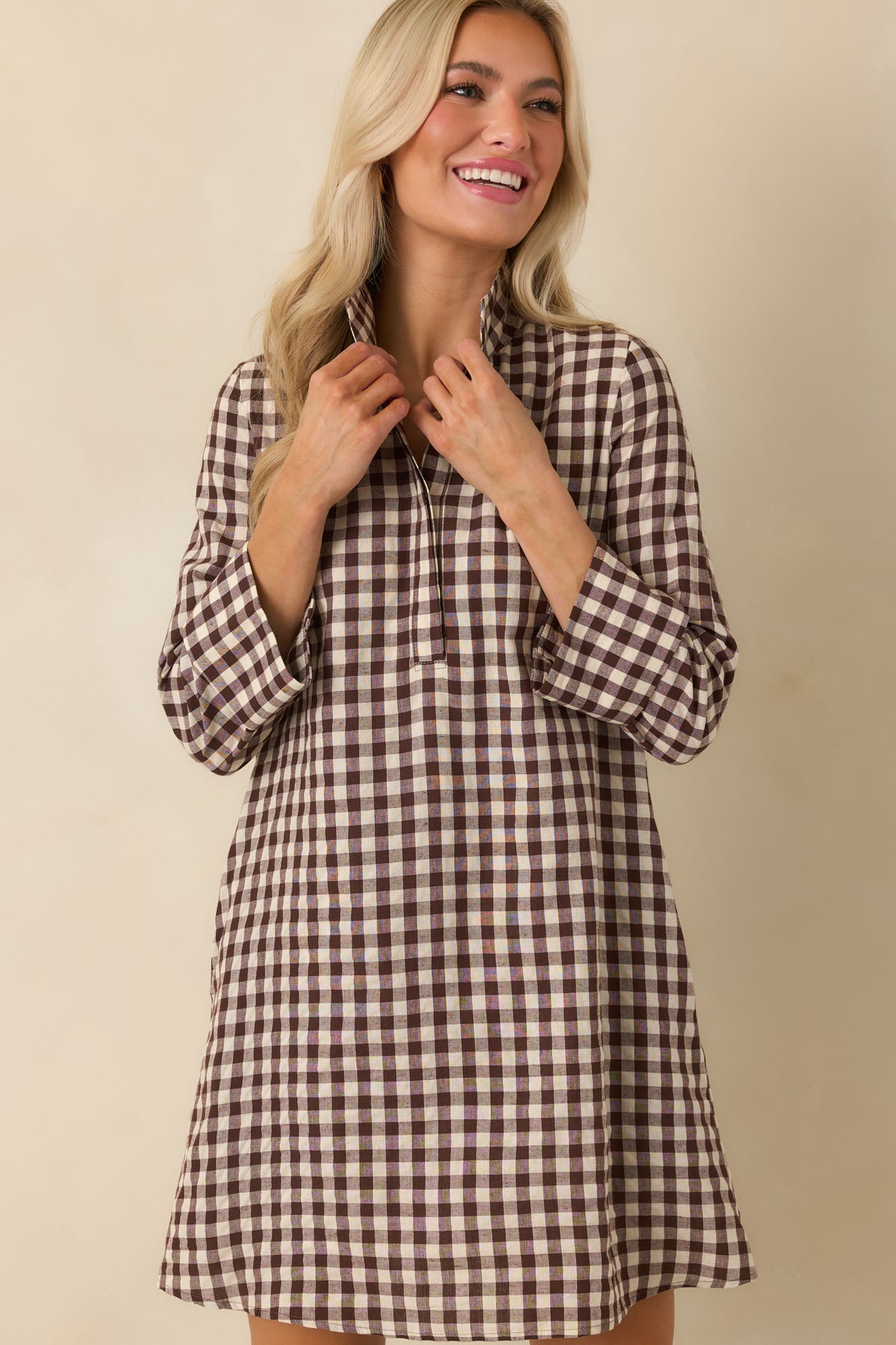 Chocolate brown and ivory gingham mini dress highlighting the clean concealed placket and structured collar.