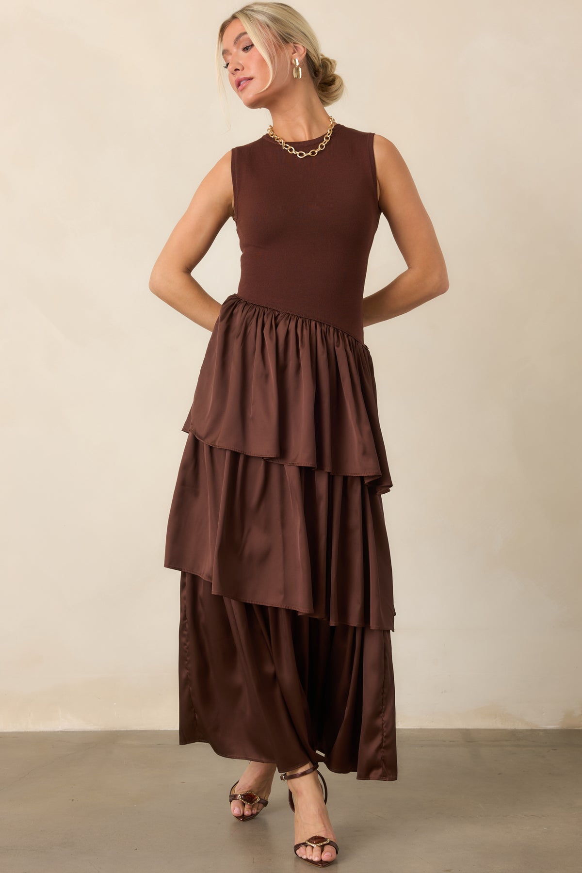 Rich chocolate brown dress combines a streamlined knit bodice with a diagonal waist seam and flowing woven layers.