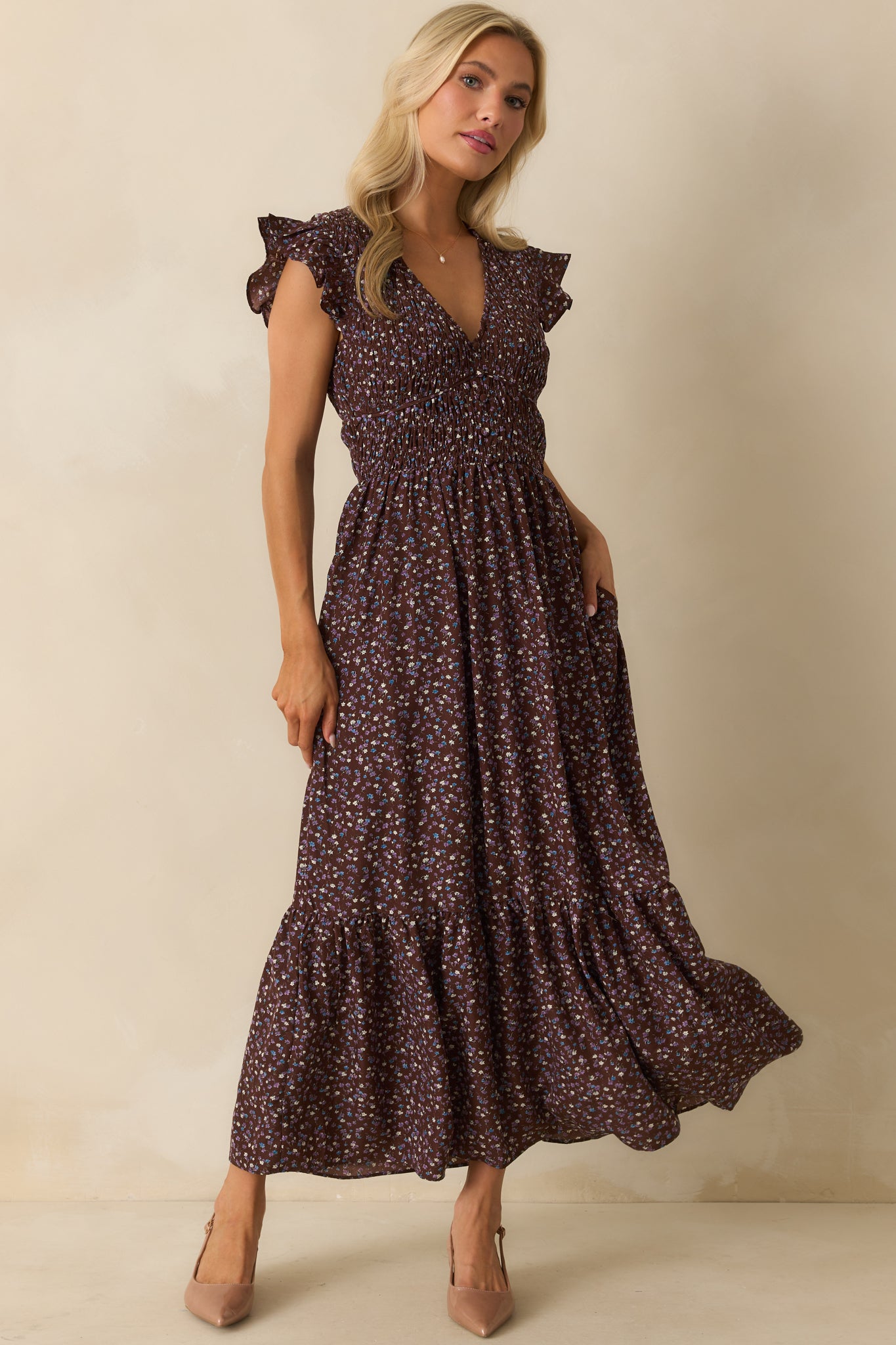 Chocolate brown maxi dress with a V-neckline, smocked bodice, and flutter sleeves, finished with piping trim accents.