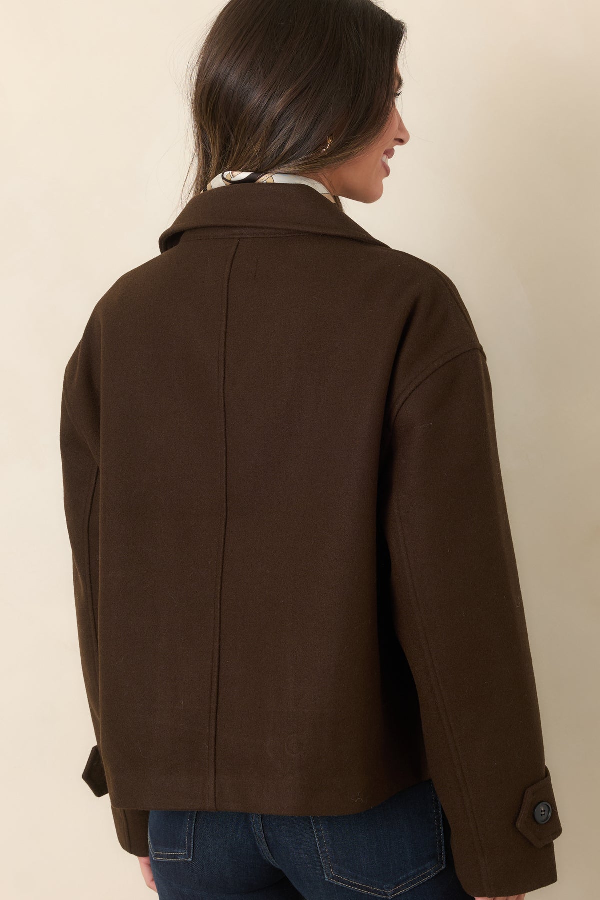 Rich chocolate brown jacket showcasing the relaxed boxy silhouette and dropped shoulders from the rear.