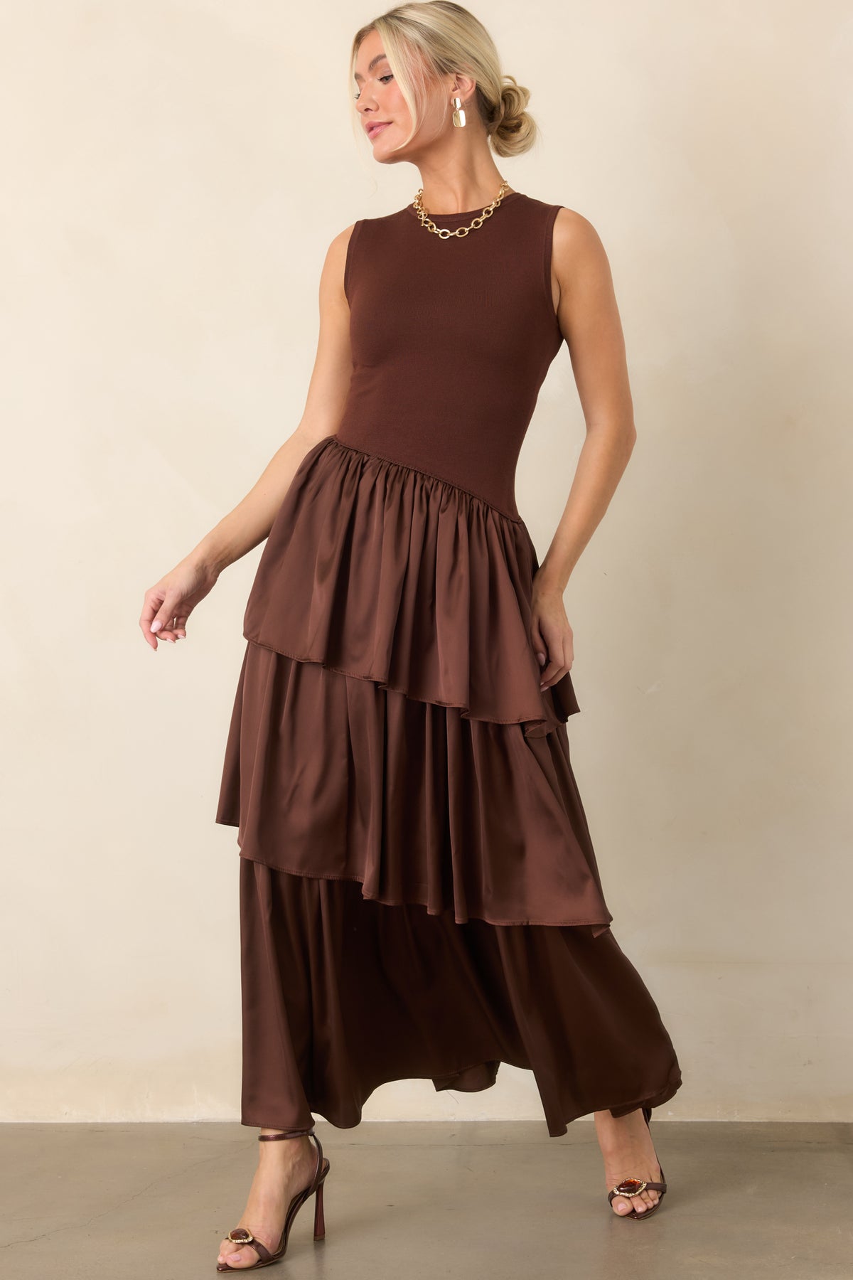 Chocolate brown dress features a fitted sleeveless knit bodice, round neckline, and cascading woven skirt layers.
