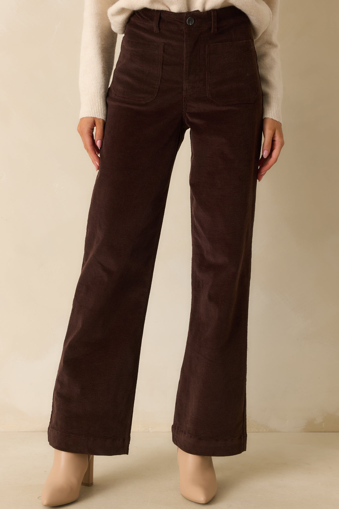 Front view focused on the top of chocolate brown corduroy pants, showcasing the button and zip closure.
