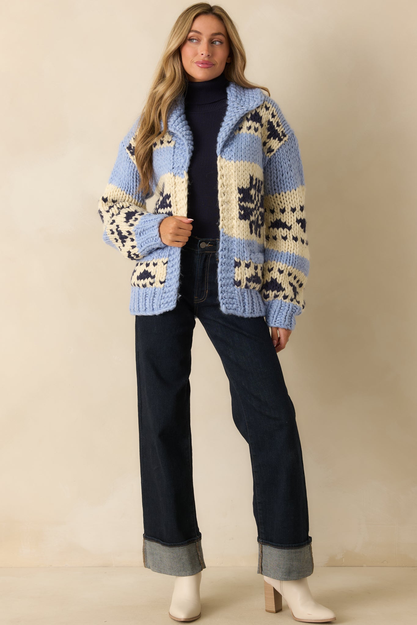 Chunky knit cardigan with colorblock pattern in blue, cream, and navy, featuring open front, drop shoulders, and long sleeves.