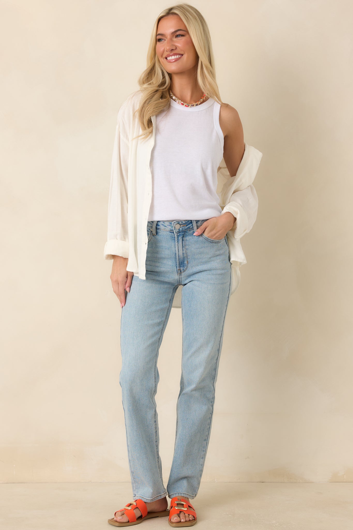 Classic white tank top highlighting the close-to-the-body fit, simple silhouette, and effortless wardrobe appeal.