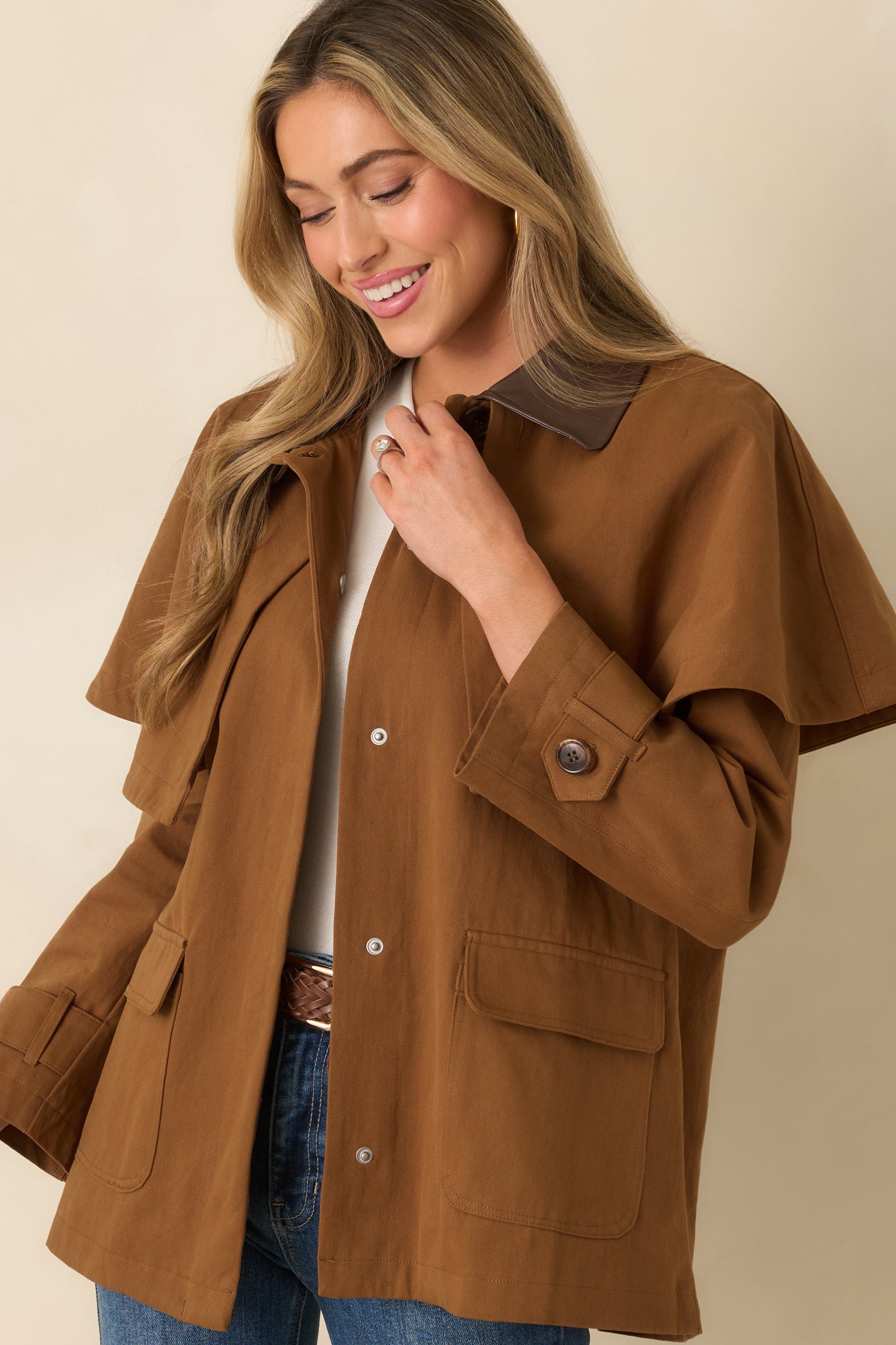 Close front crop highlighting collared neckline and flap patch pockets on brown cotton jacket.