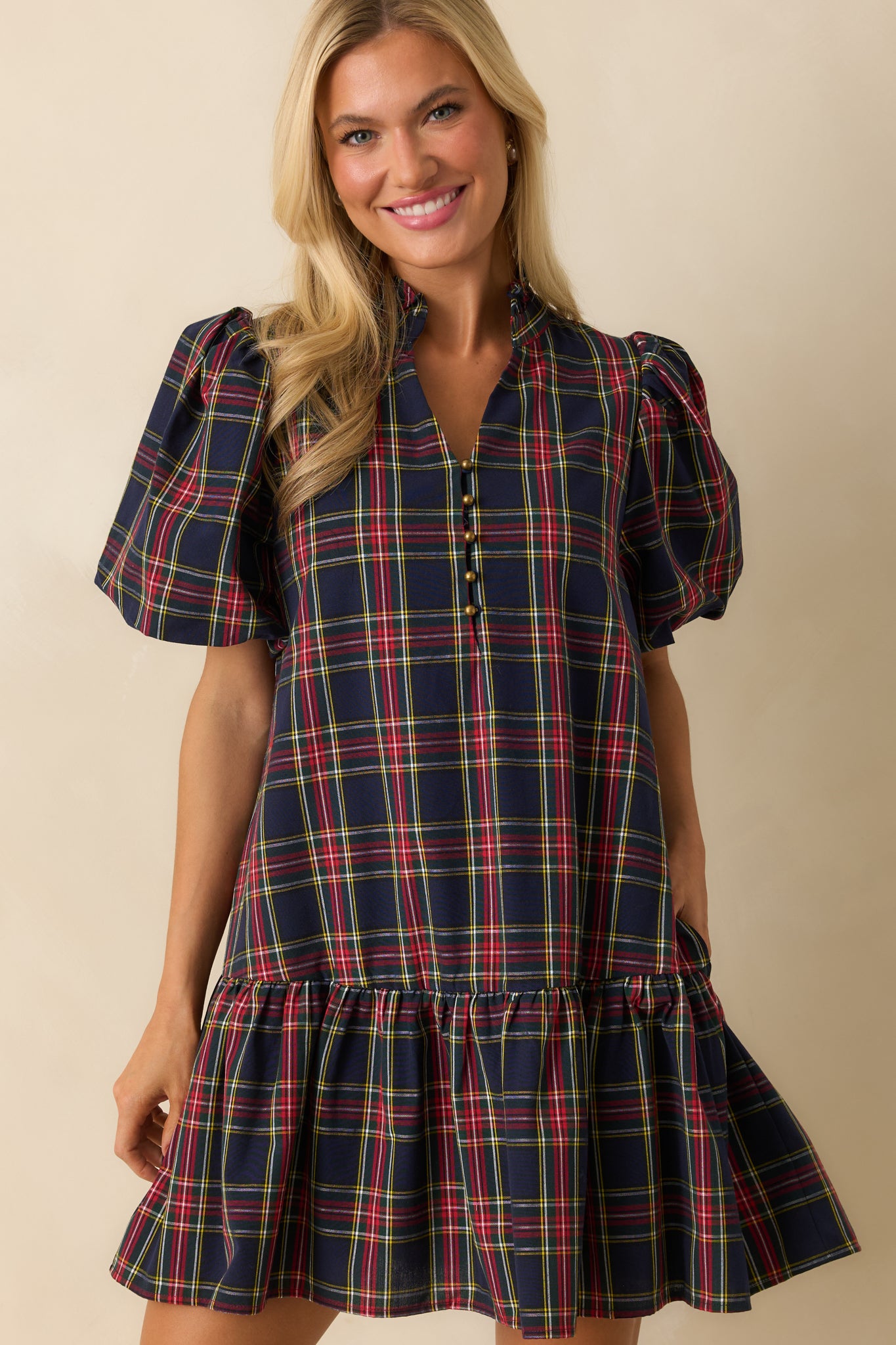 Close crop of split neckline with button detail and puff sleeves on the navy plaid mini dress.