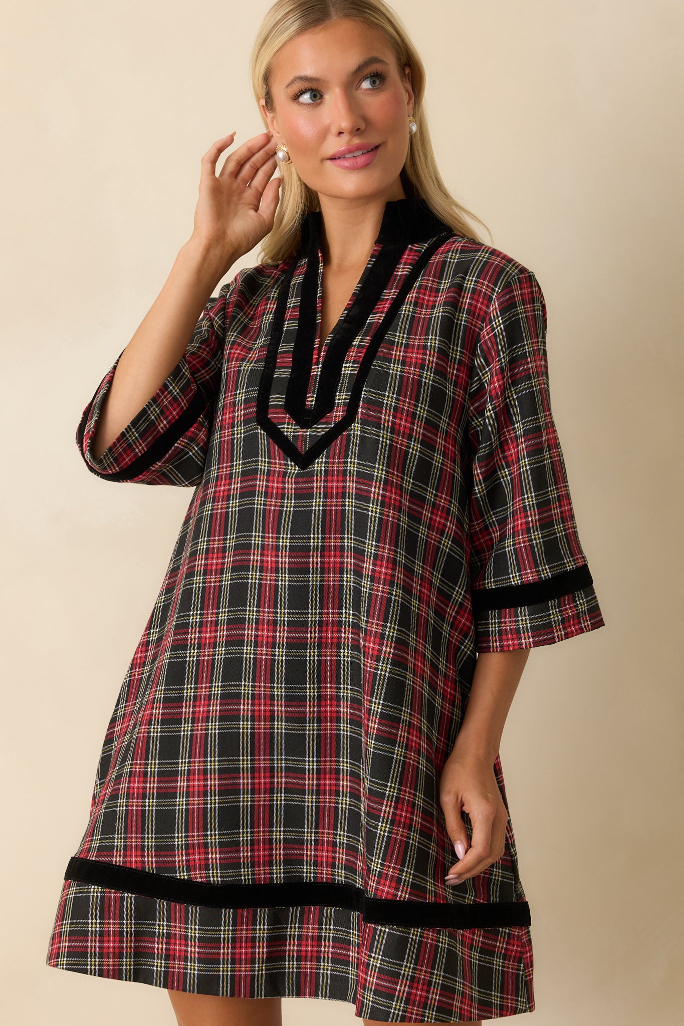 Close crop of split neckline and black velvet trim on the red and black plaid mini dress.
