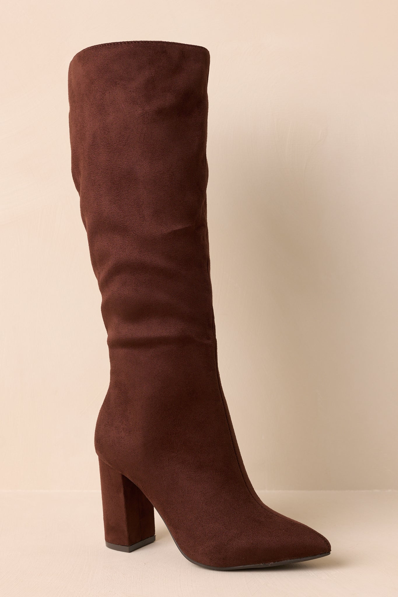 Close crop highlighting tall block heel and smooth faux suede texture.