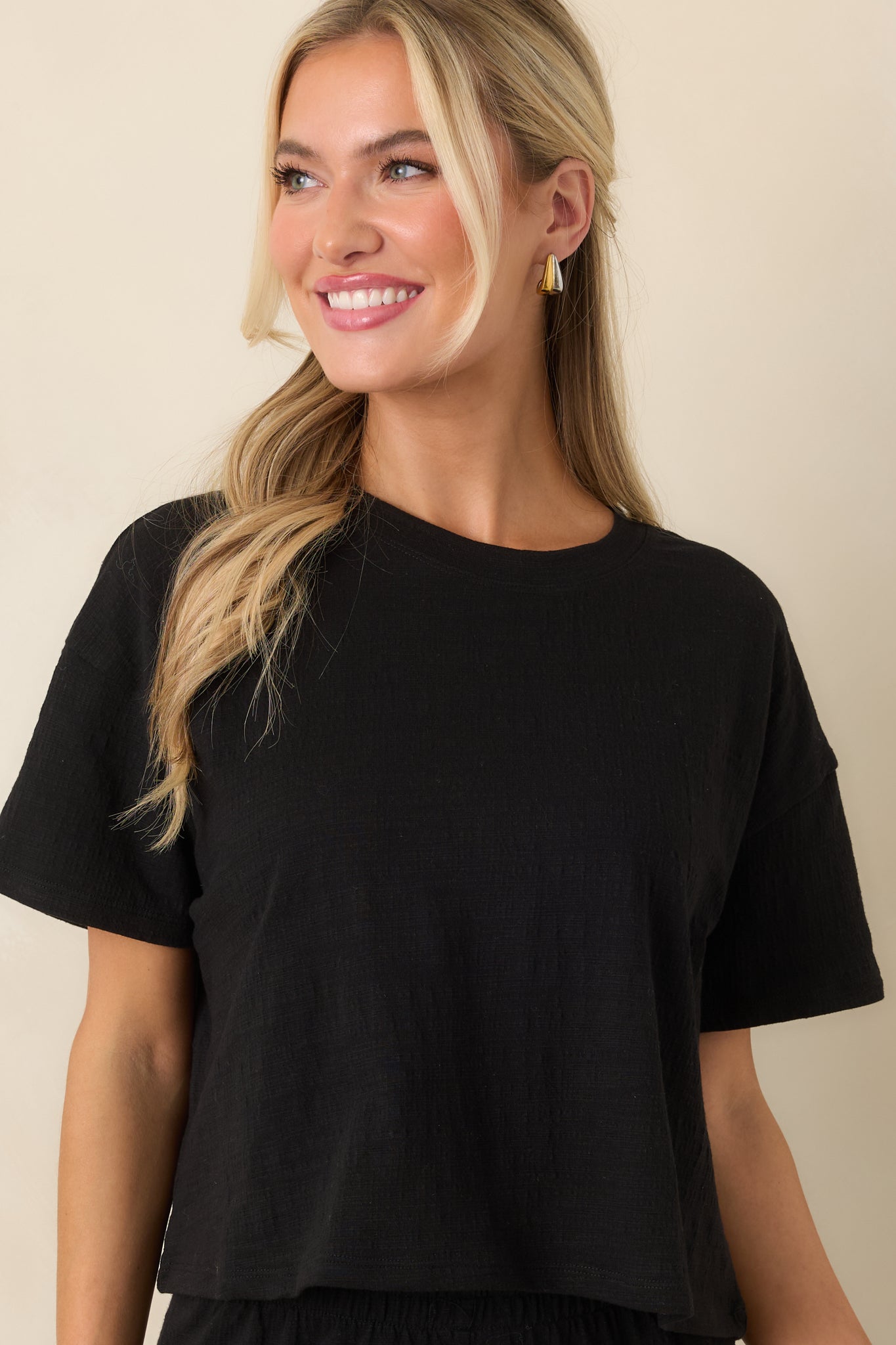 Close cropped angle highlighting the soft black texture and short sleeve construction.
